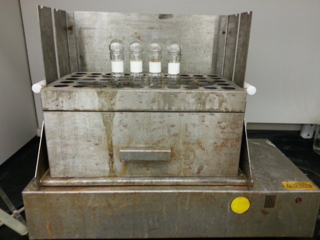 Laboratory heating block with vials; sample incubation for chemical reaction studies.