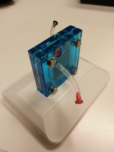 Fuel cell setup; blue electrochemical cell on white base for energy conversion studies.