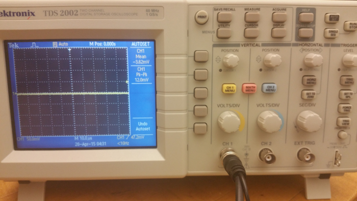 Oscilloscope display with waveform; voltage measurement; electronic signals analysis; data output.