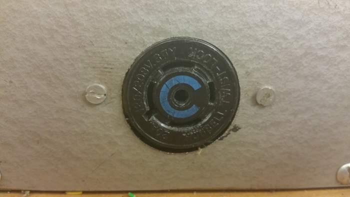 Electric circuit component with voltage marking, showing part of electronic equipment setup.
