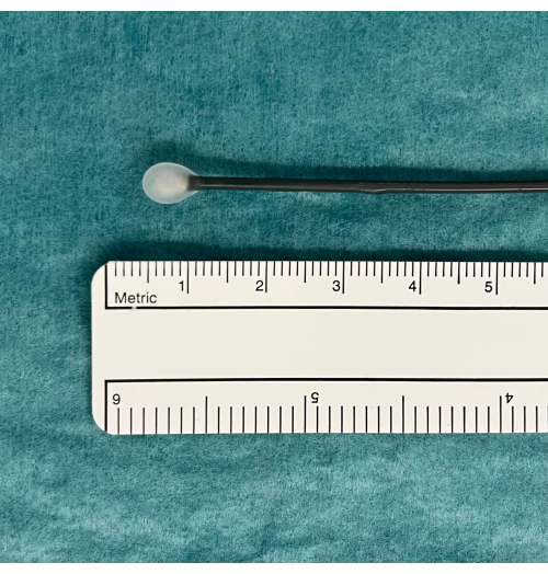 Swab measured with metric ruler on teal surface, precision tool for sample collection size analysis.