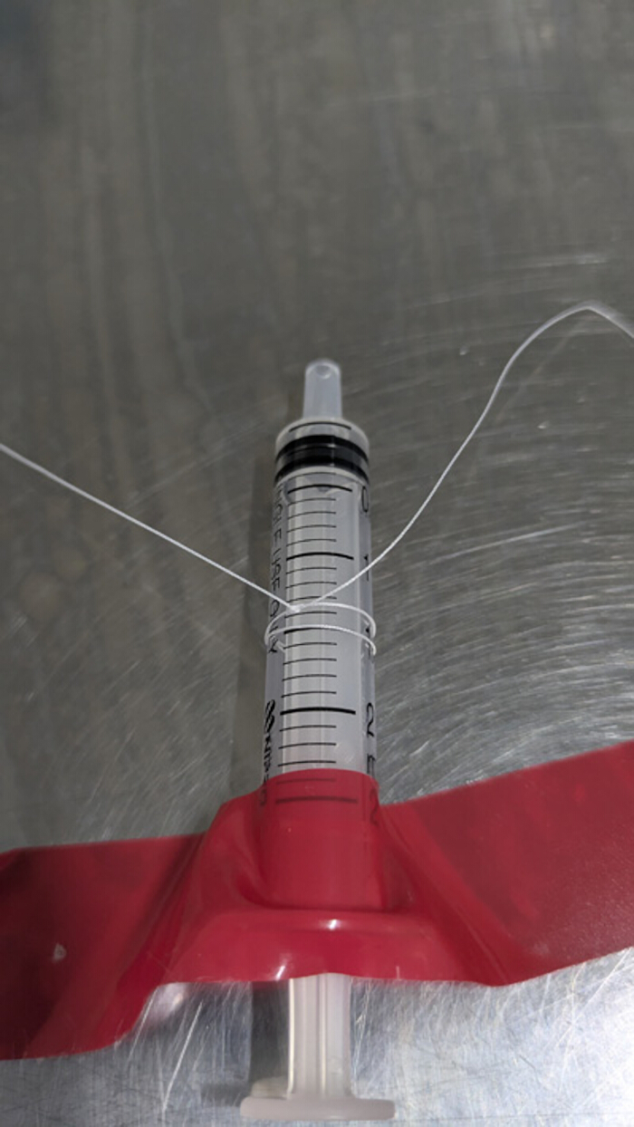 figure-protocol-3 Static equilibrium experiment with syringe; balance setup for force analysis demonstration.